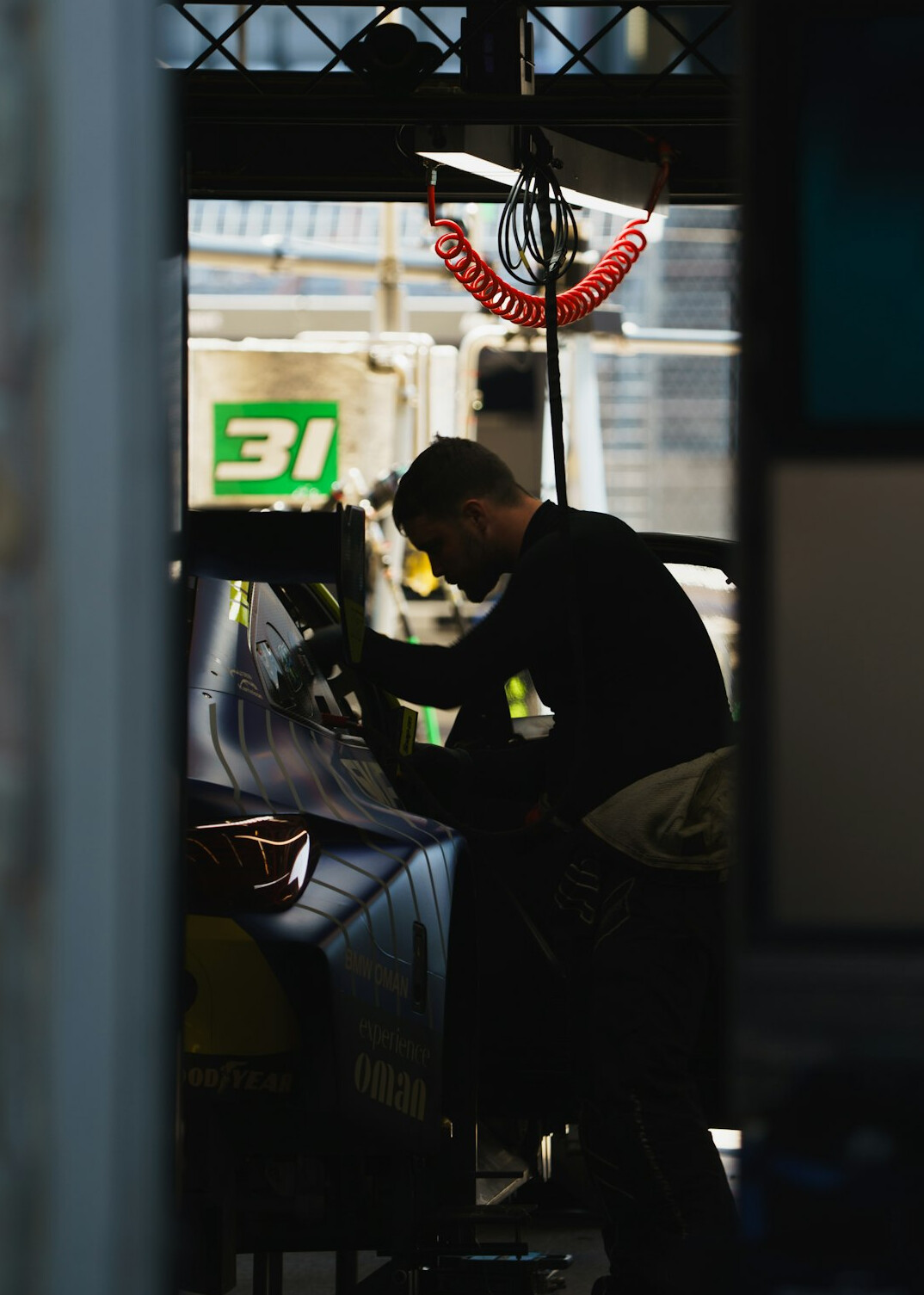 Mechanic inspecting a car body panel in a garage