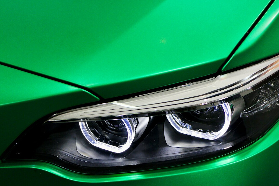 Close-up of a car headlight and surrounding paint